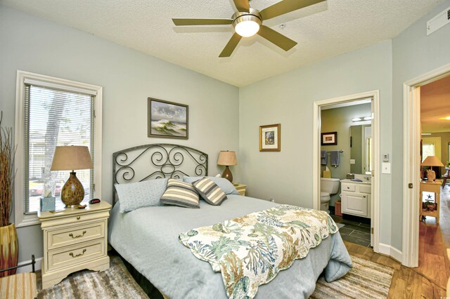 1401 Lighthouse Dr Unit 4226, North Myrtle Beach, SC 29582 - bedroom featuring connected bathroom, a textured ceiling, a ceiling fan, wood finished floors, and visible vents