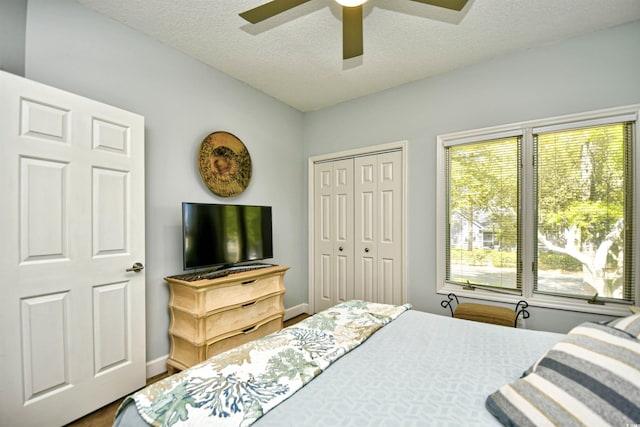 bedroom featuring a ceiling fan, a textured ceiling, baseboards, and a closet