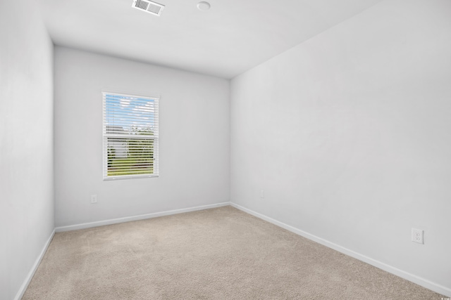 empty room featuring baseboards, carpet floors, and visible vents