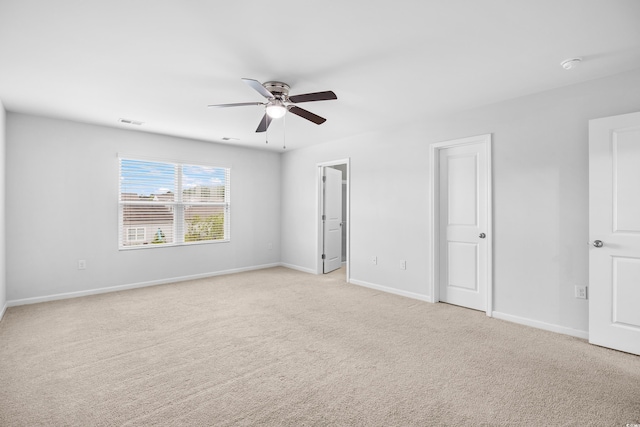 unfurnished bedroom featuring baseboards, ceiling fan, light carpet, and visible vents