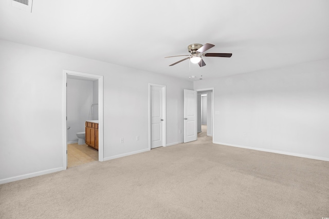 unfurnished bedroom featuring visible vents, light carpet, baseboards, ensuite bathroom, and a ceiling fan