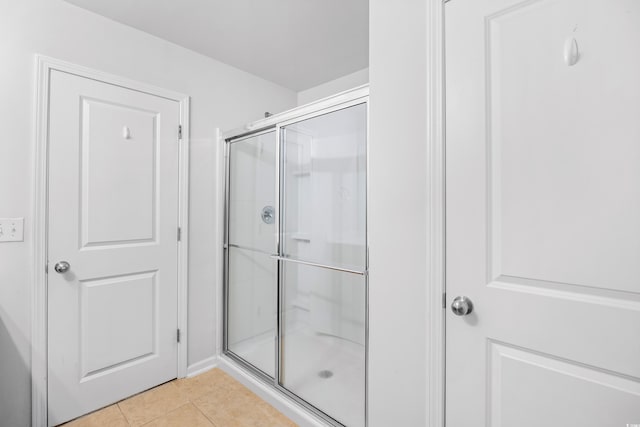 bathroom featuring tile patterned floors and a shower stall