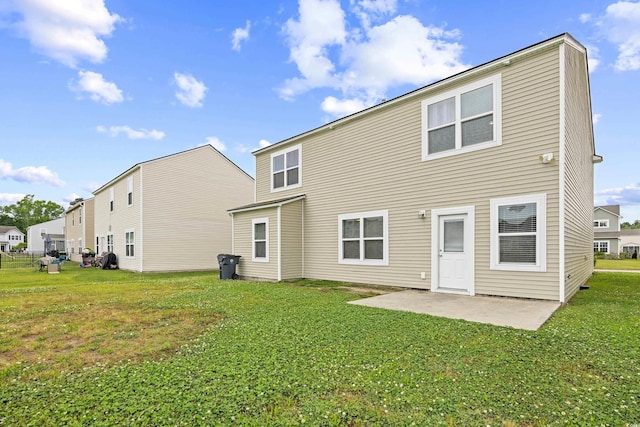 rear view of house with a patio and a yard