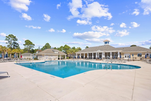 community pool featuring fence and a patio area
