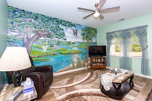 40 Parkside Dr, Pawleys Island, SC 29585 - living room with wood finished floors, wallpapered walls, a ceiling fan, an accent wall, and baseboards