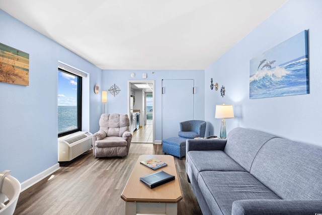 living area with baseboards, a wall mounted AC, and wood finished floors