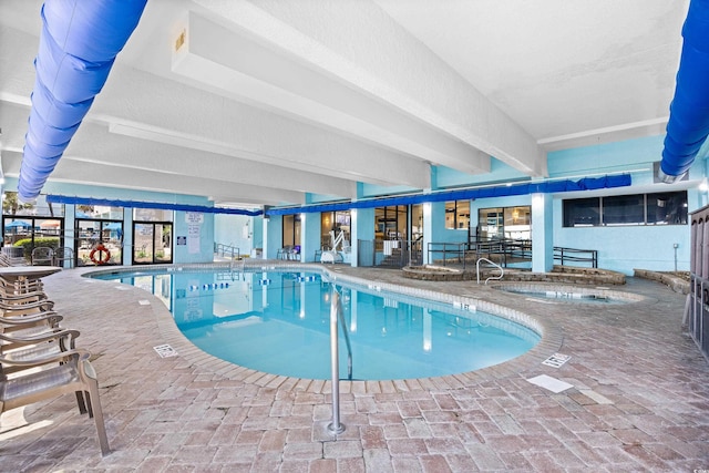 community pool with a patio and an indoor in ground hot tub