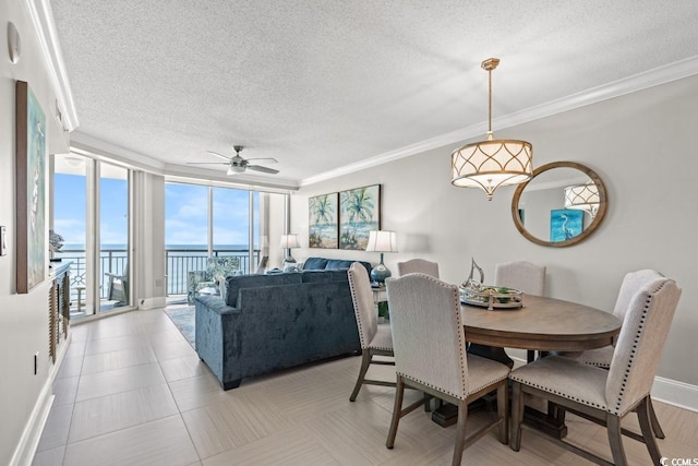 dining room featuring a water view, a ceiling fan, a textured ceiling, crown molding, and expansive windows