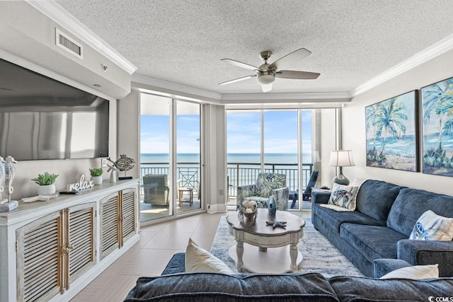 living room featuring a water view, a ceiling fan, a textured ceiling, and crown molding