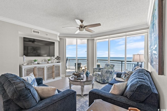 living room featuring a ceiling fan, crown molding, and a textured ceiling