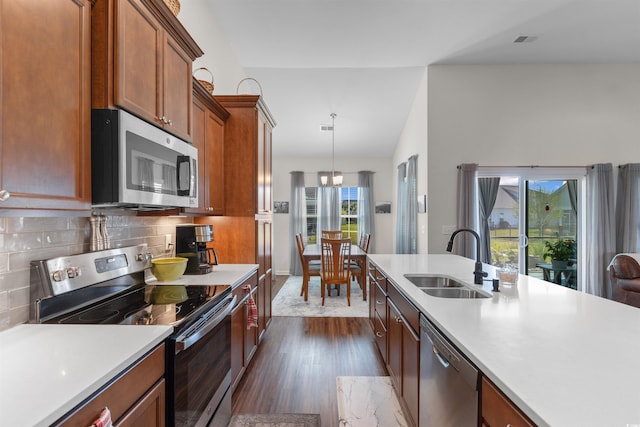 kitchen featuring appliances with stainless steel finishes, a sink, dark wood-style flooring, light countertops, and brown cabinets