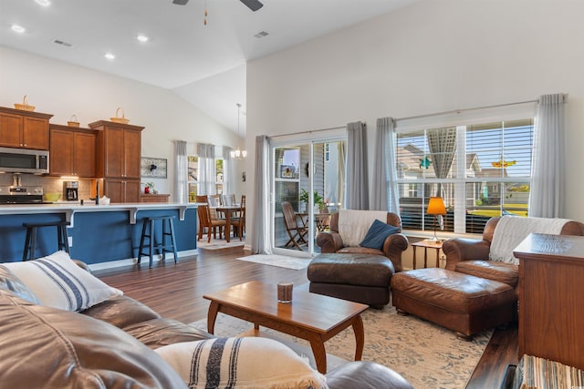 living area with healthy amount of natural light, wood finished floors, ceiling fan, high vaulted ceiling, and recessed lighting