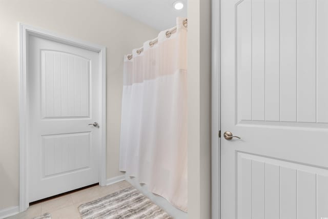 bathroom with tile patterned floors, curtained shower, and baseboards