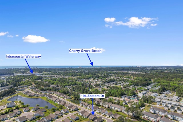 aerial view of property's location with a nearby body of water and nearby suburban area