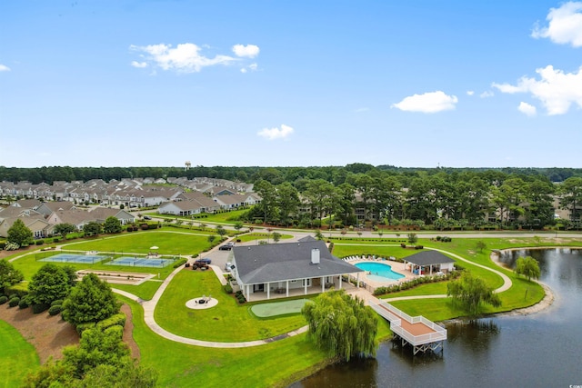 aerial perspective of suburban area featuring a nearby body of water and a pool