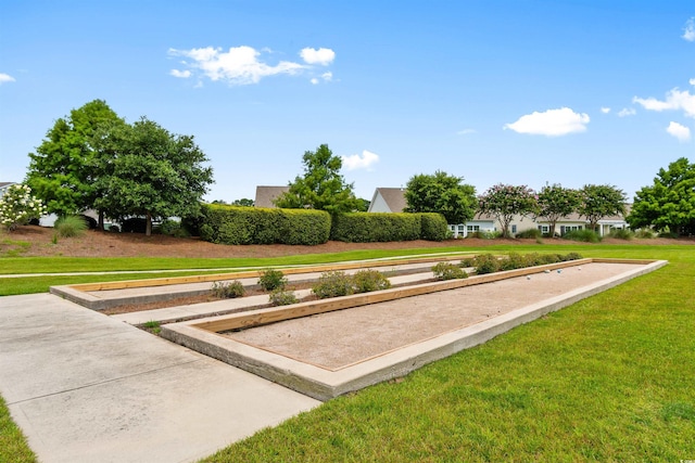 view of property's community featuring a bocce ball area and a lawn