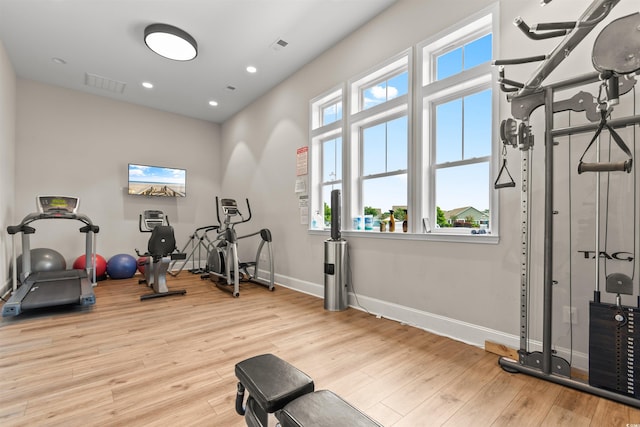 exercise area with wood finished floors, baseboards, and recessed lighting