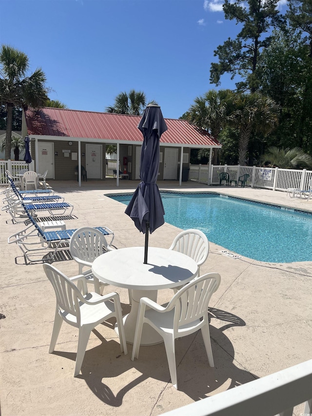 community pool featuring fence and a patio