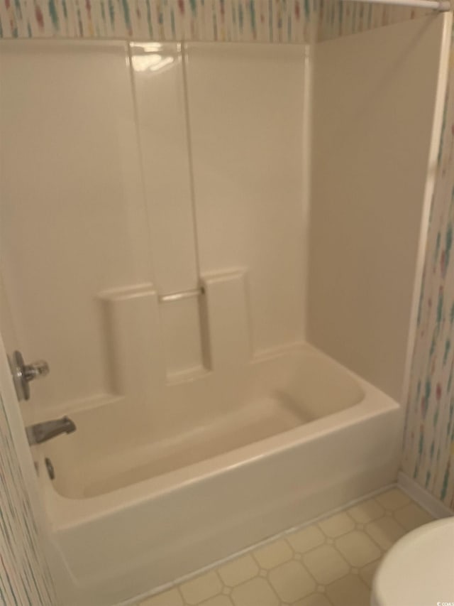 bathroom featuring shower / bathtub combination, toilet, and tile patterned floors