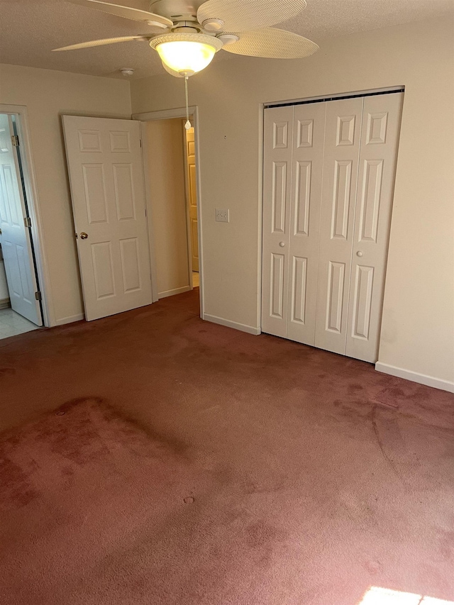 unfurnished bedroom featuring carpet floors, a ceiling fan, baseboards, and a closet