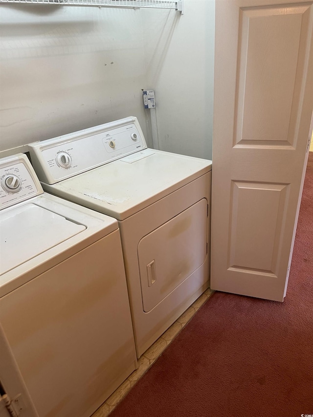 washroom with washer and dryer, laundry area, and light carpet