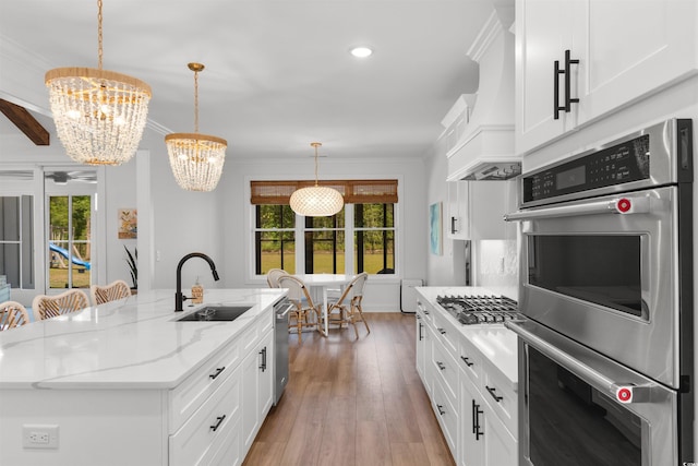 kitchen with a chandelier, appliances with stainless steel finishes, plenty of natural light, and a sink