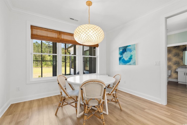 dining area with an inviting chandelier, light wood-style floors, baseboards, visible vents, and ornamental molding