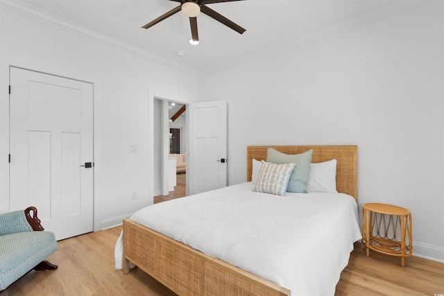 bedroom with baseboards, ornamental molding, a ceiling fan, and light wood-style flooring