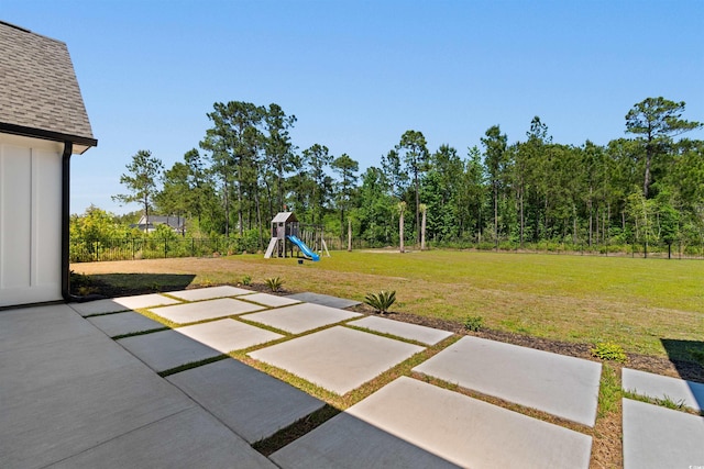 view of yard featuring a playground, a patio area, and fence
