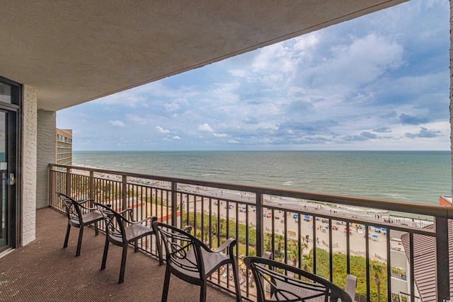 balcony with a water view and a view of the beach