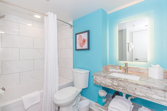 full bath with a sink, baseboards, toilet, and shower / bathtub combination with curtain