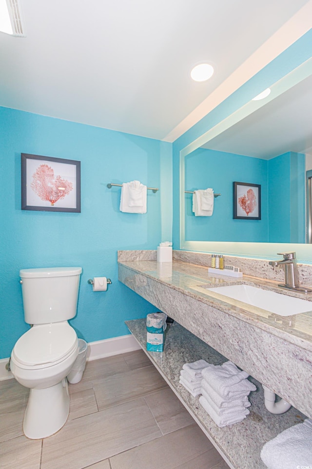 bathroom featuring a sink, baseboards, and toilet