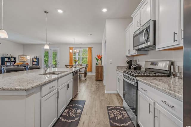 847 Flowering Branch Ave, Little River, SC 29566 - kitchen with appliances with stainless steel finishes, a sink, white cabinets, light wood-style flooring, and a chandelier