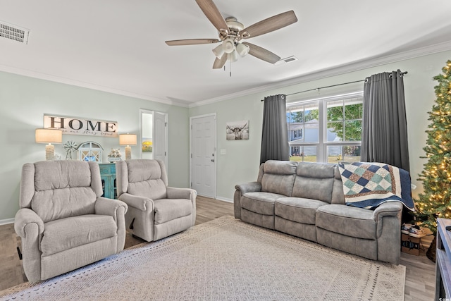 living room with crown molding, wood finished floors, a ceiling fan, and baseboards