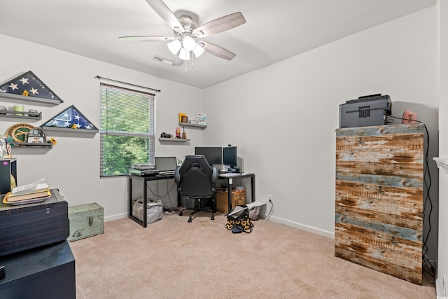 carpeted office space with a ceiling fan and baseboards