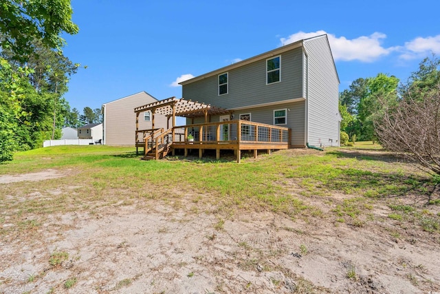 rear view of house featuring a pergola, a wooden deck, and a lawn
