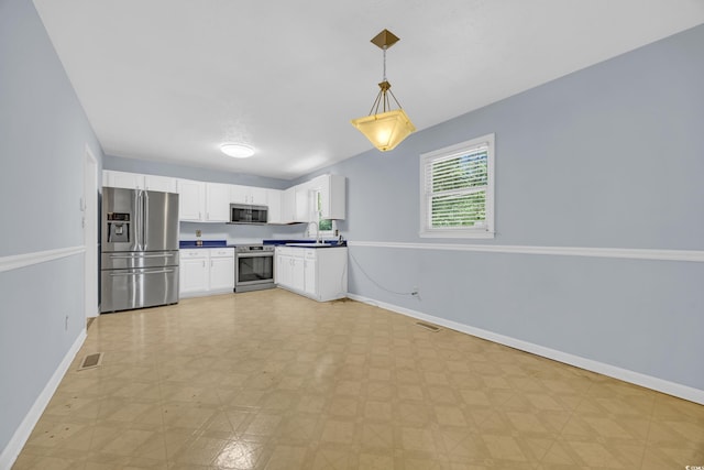 kitchen featuring stainless steel appliances, baseboards, white cabinets, and pendant lighting