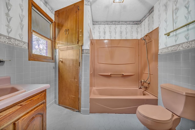 full bathroom featuring tile walls, tile patterned floors, toilet, a wainscoted wall, and vanity