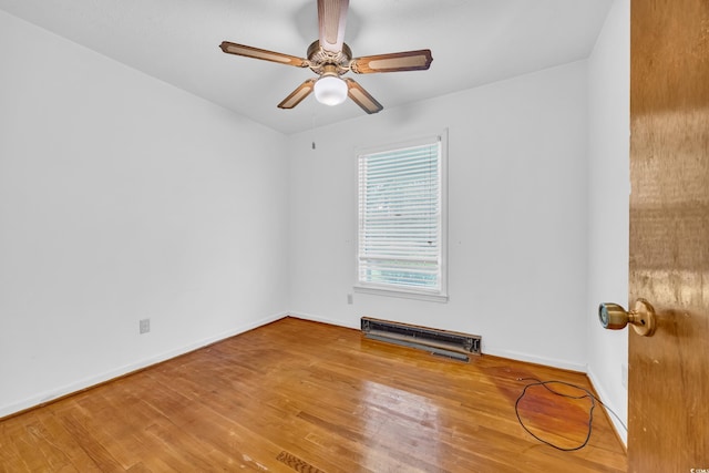 empty room with wood finished floors, baseboards, and a ceiling fan