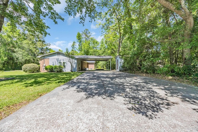 view of front of property featuring asphalt driveway, a front lawn, and a carport