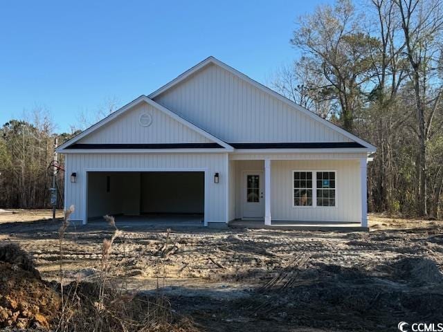 view of front of property with an attached garage, a porch, and driveway