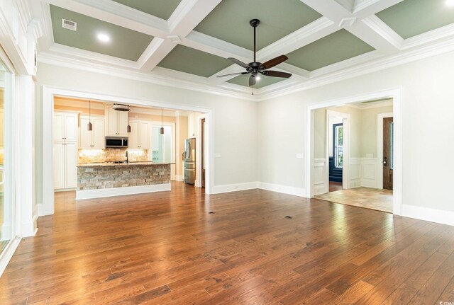 1400 James Island Ave, North Myrtle Beach, SC 29582 - unfurnished living room featuring coffered ceiling, ceiling fan, wood finished floors, ornamental molding, and beamed ceiling