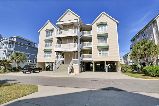 view of building exterior featuring stairway and a carport