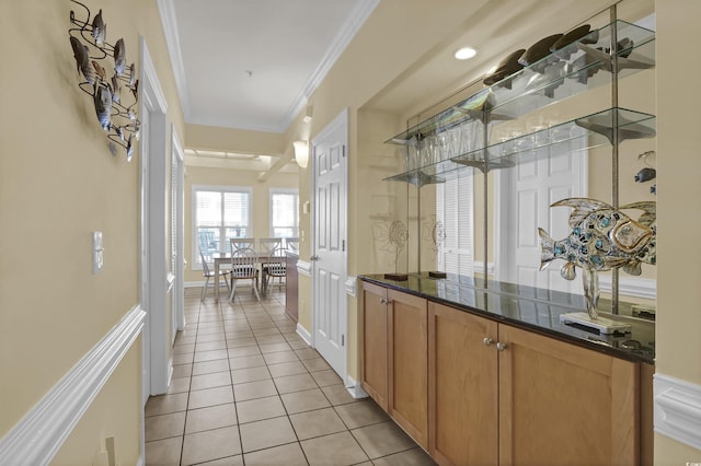 bar with ornamental molding and light tile patterned floors