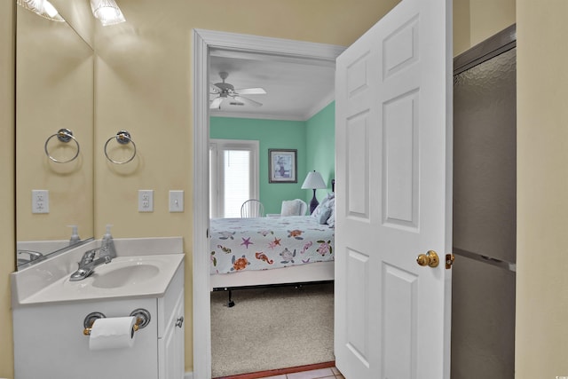 bathroom with crown molding, ceiling fan, and vanity