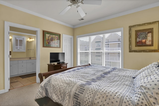 bedroom featuring visible vents, crown molding, light tile patterned floors, light carpet, and ensuite bath