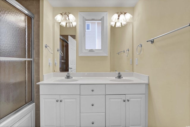 bathroom with a sink, an enclosed shower, and double vanity