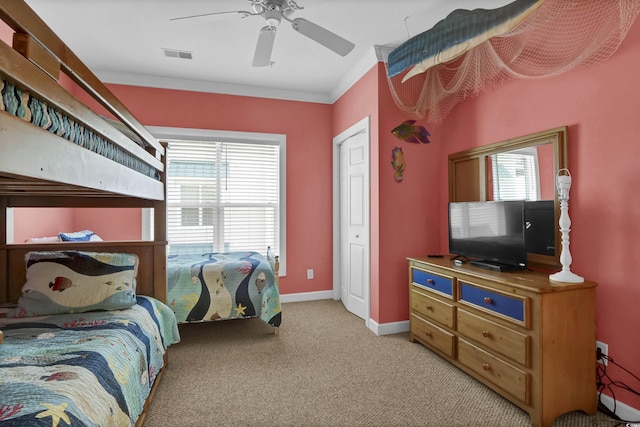 bedroom featuring ceiling fan, visible vents, baseboards, ornamental molding, and light carpet