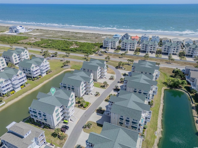 birds eye view of property with a water view and a view of the beach