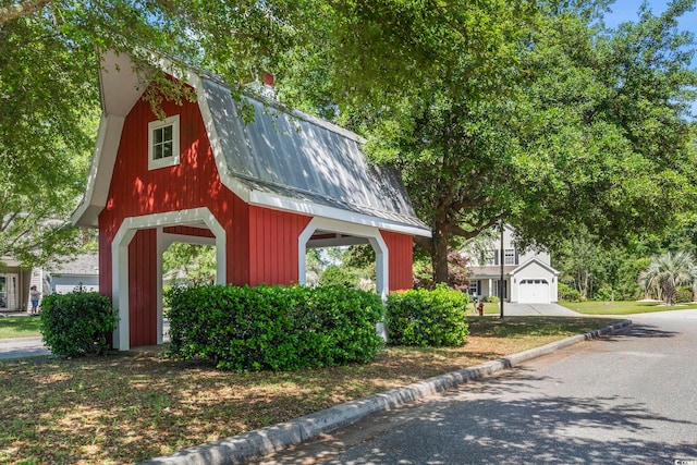 exterior space featuring a chimney, a gambrel roof, and metal roof